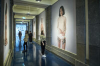 Ground floor corridor, people viewing large photographic artworks, for Documenting the Body: curated by Stanislava Pinchuk, of people with tattoos by Paul Stillen, photographed by Lekhena Porter. From Our Bodies, Our Voices, Our Marks: a suite of exhibitions, including 'Perseverance: Japanese Tattoo in a Modern World', 'Tatau: Marks of Polynesia' and 'Documenting the Body: curated by Stanislava Pinchuk'